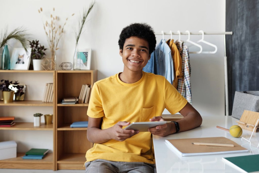 A molecada e a Internet no Brasil: o que atrai os jovens online 7 Um jovem de camiseta amarela com um tablet na mão
