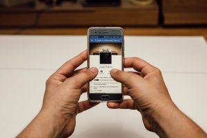 Pessoa segurando um celular com uma página do facebook aberta