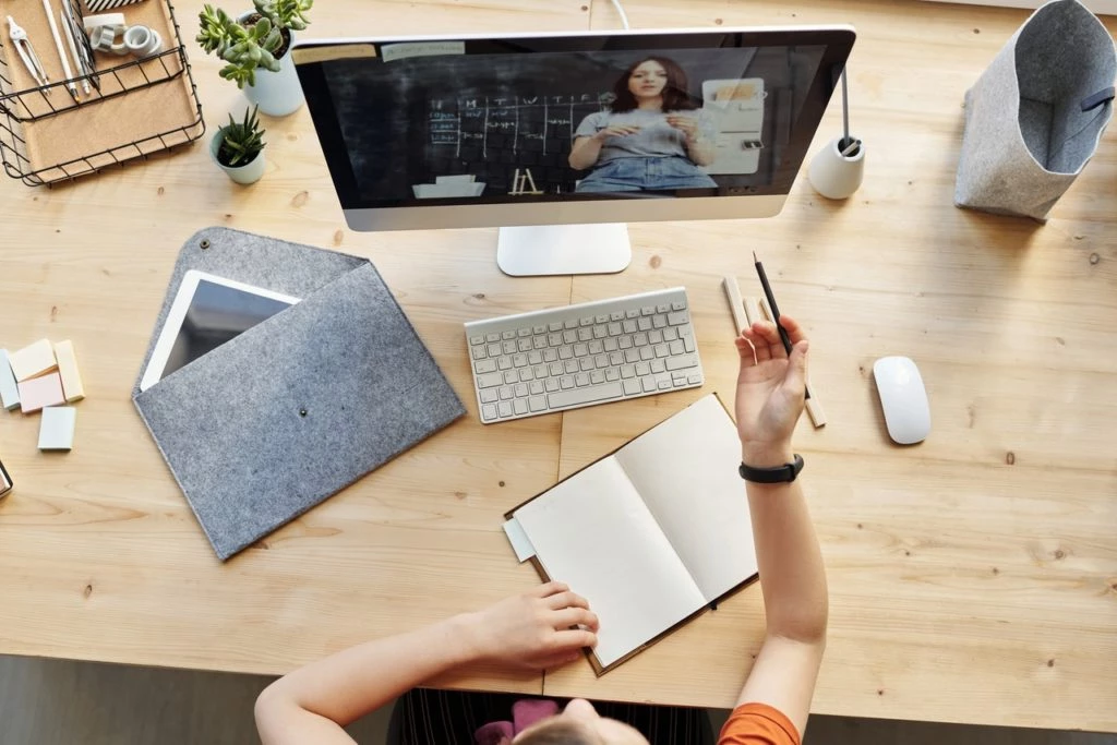Curso de marketing digital: 13 cursos online e gratuitos 20 Pessoa com um caderno assistindo a um Curso de Marketing Digital
