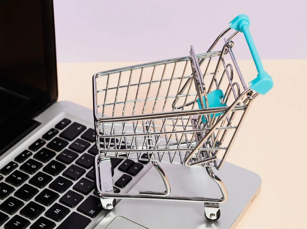 Imagem de um carrinho de compra e de um notebook
